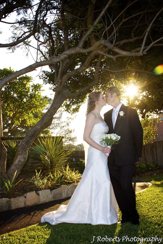 Kissing couple with setting sun - wedding photography sydney